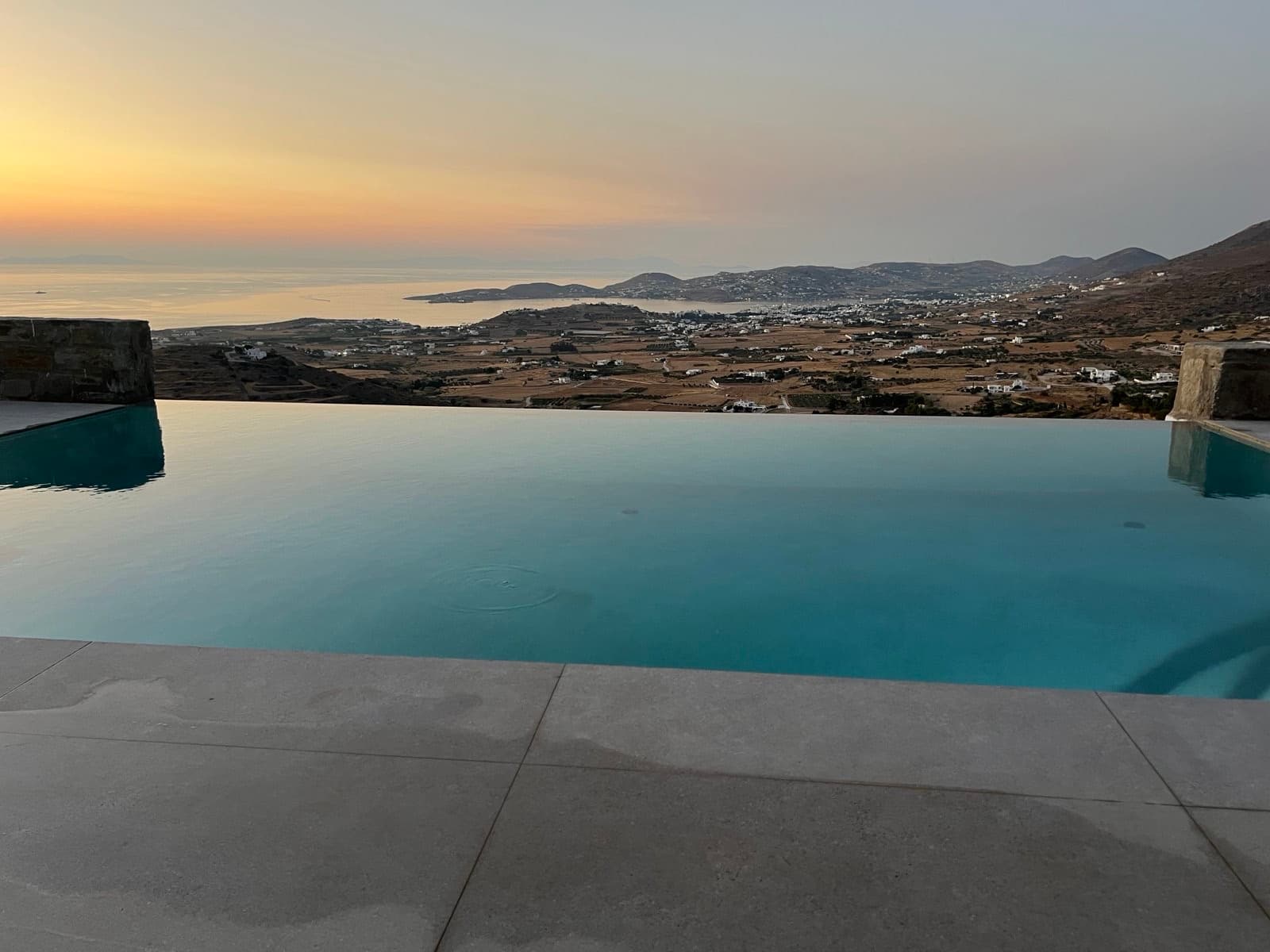 Calm dusk view across the pool and Parikia bay at Theasis Paros