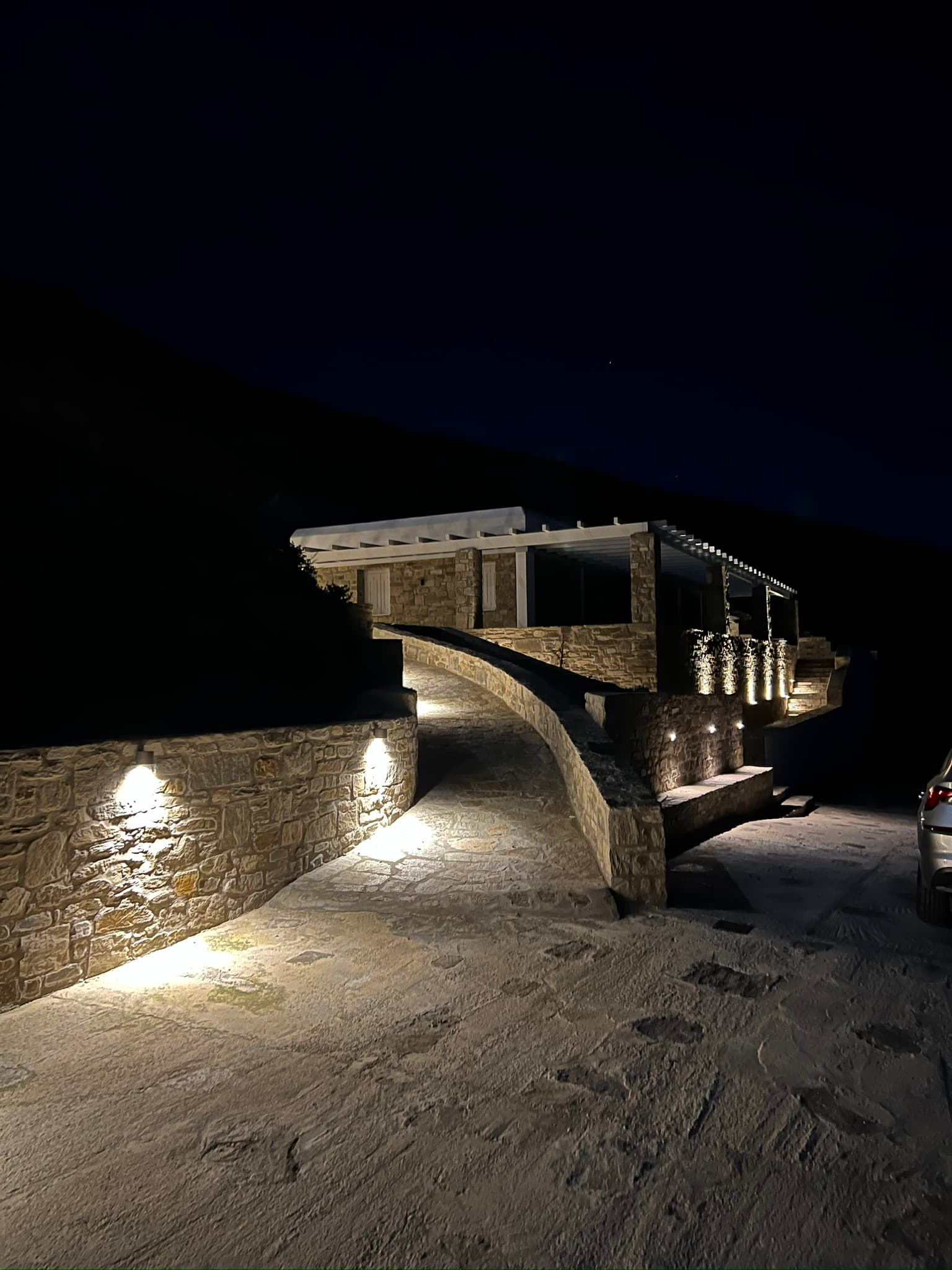 Theasis Paros illuminated at night with the hillside arrival lit softly