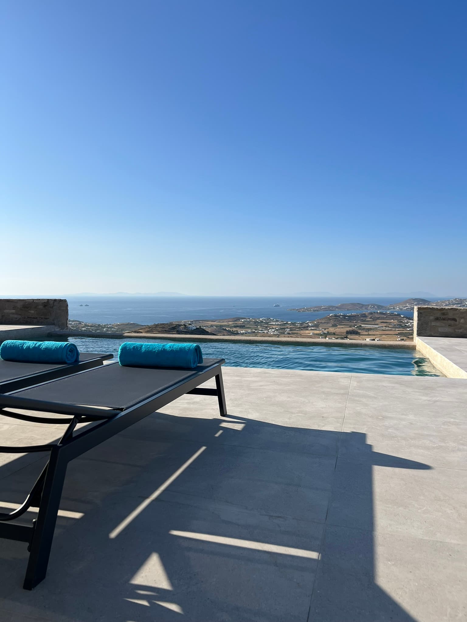 Pool loungers and sea view across Parikia bay at Theasis Paros